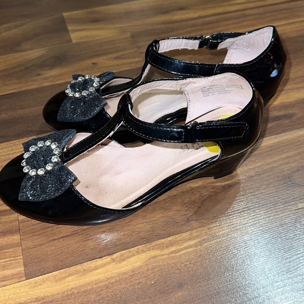Black dress shoes has a bow in the front and rhinestones.